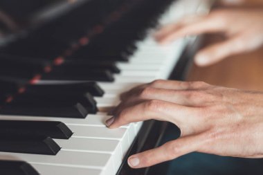 Adam evde piyano çalıyor. Piyano ve ellerin kırpılması.