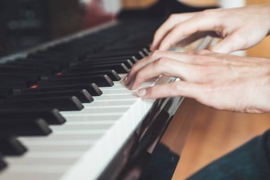 Adam evde piyano çalıyor. Piyano ve ellerin kırpılması.