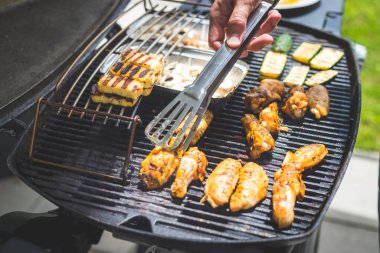 Gaz ızgarasında tavuk kanadı, peynir ve sebze yakın. Yaz zamanı, açık havada..