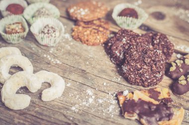 Geleneksel Avrupa ev yapımı Noel kurabiyelerinin kırsal ahşap masa üzerindeki çeşitliliği