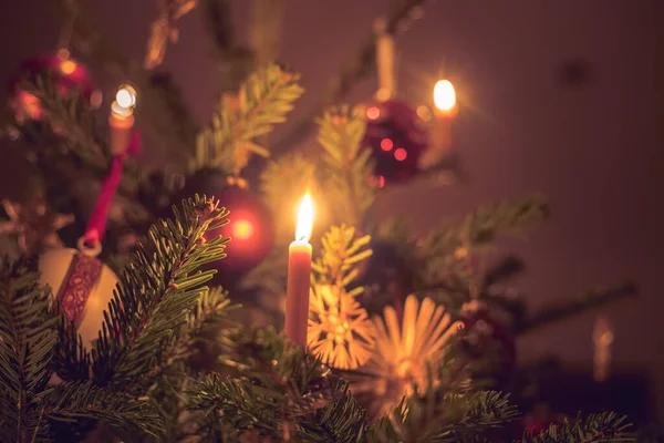 挂在装饰过的圣诞树树枝上的蜡烛 — 图库照片