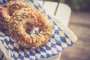 Kahvaltı için taze Bavyera krakerleri, açık havada ahşap bir masada yatıyor.