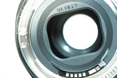 Fotoğrafçı elinde profesyonel bir fotoğraf optiği tutuyor. Bulanık arkaplanda dizüstü bilgisayar. 