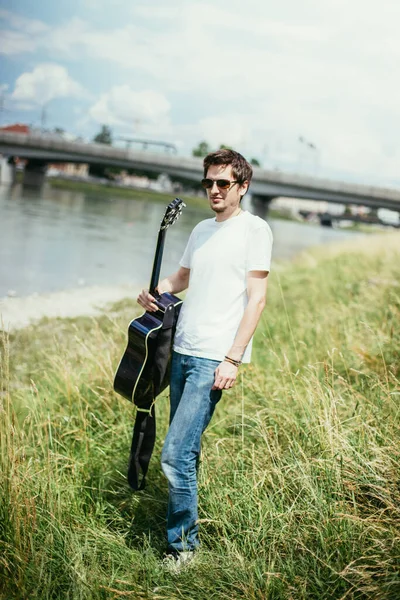 Junger Mann Sitzt Einem Fluss Und Spielt Westerngitarre — Stockfoto