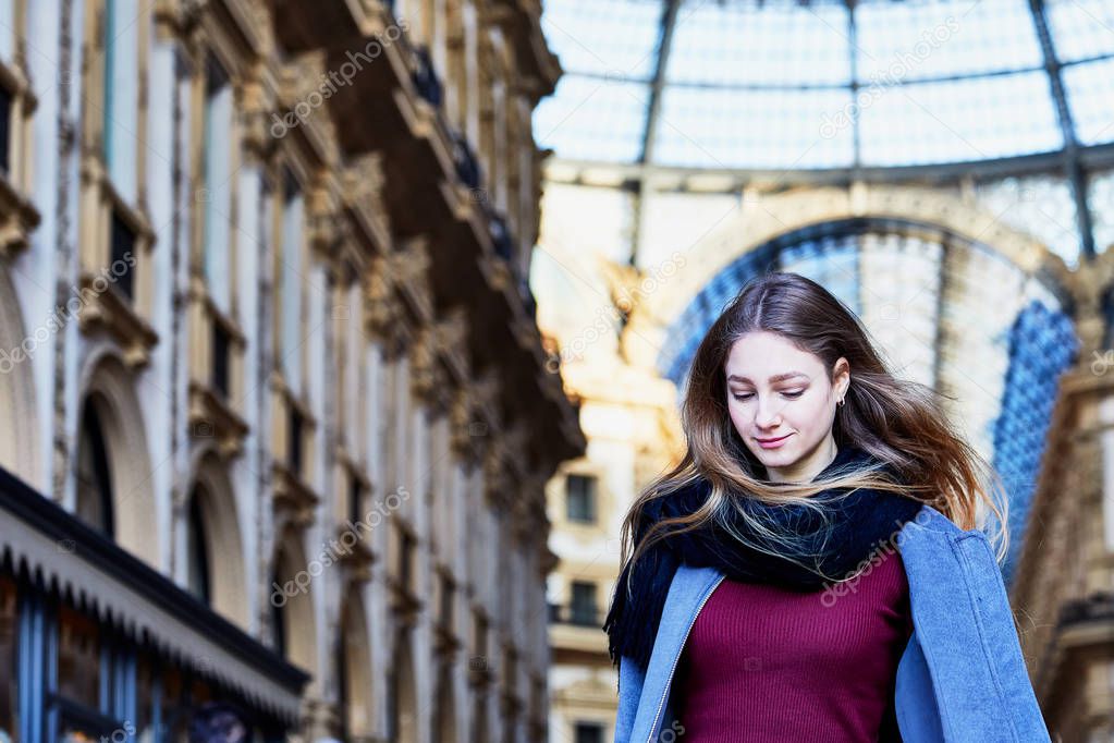 Girl daydreaming while walking inside of Galleria Vittorio Emanuele II in Milan Italy