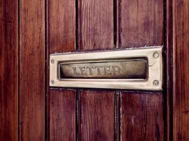 Ahşap kapılar altın ayrıntıları ile yer alan posta mektup kutusu