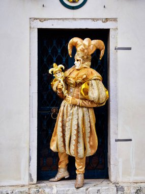 Venice, İtalya - 1 Mart 2019 A kişi ile altın Arlequin Kostüm giymiş