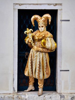 Venice, İtalya - 1 Mart 2019 A kişi ile altın Arlequin Kostüm giymiş