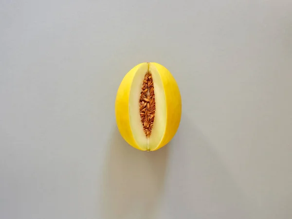 上から見ると灰色の背景で分離された黄色のメロン果実 - flatlay 見て - イメージ — ストック写真