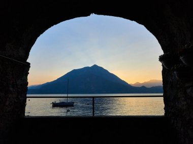 Varenna, İtalya 30 Mart 2019 Como Gölü istirahat arka plan olarak gün batımı ile tekne