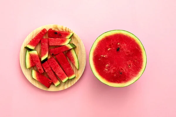 Pastèque coupée en deux et tranches isolées dans le fond de Brouillard rose — Photo