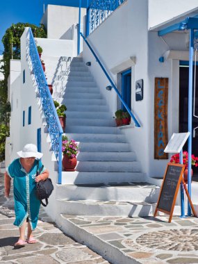 Merdivenile beyaz bina tarafından yürüyen kıdemli kadın