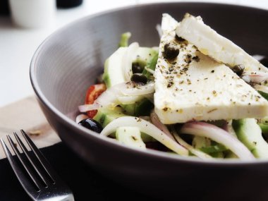 Taze sebze ve baharat ile beyaz peynir ile Closeup lezzetli Yunan salatası ve kil kase servis