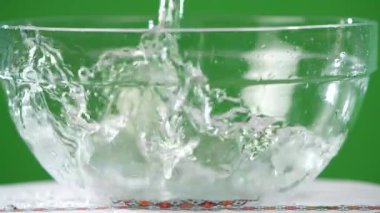 Su yeşil bir arka planda yemeklerden içine dökülen 2