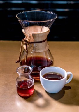 Metodo Chemex de preacion de cafe, servido en una taza y jarra de vidrio