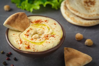 Nohut humus gri arka plan üzerine bir kase ve pide ekmek. Akdeniz aperatif, vejetaryen sağlıklı gıda kavramı. Üstten Görünüm, düz yatıyordu, kopya alanı.