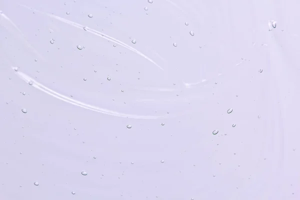 Serum, sıvı jel dokusu. Şeffaf kozmetik krem geçmişi. Temiz lavanta renkli cilt ürünü lekesi