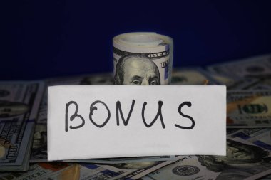 100 dolar faturaları bir boru içine bükülmüş ve dize ile bağlı. Bonus kavramı.