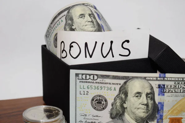 Bonus, hediye paketi ile dolar masanın üstüne beyaz bir arka plan üzerinde yazıt