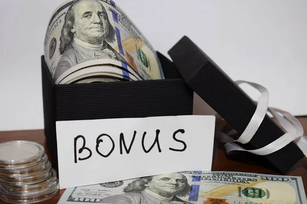 Bonus, hediye paketi ile dolar masanın üstüne beyaz bir arka plan üzerinde yazıt