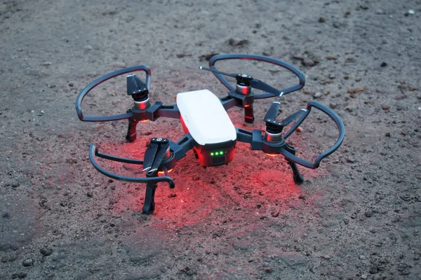 A drone with a red backlight is preparing for takeoff — Stock Photo, Image