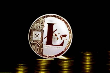 Fiziksel Litecoin Ltc sikke karanlık bir arka plan ve altın sikkeler üzerinde.