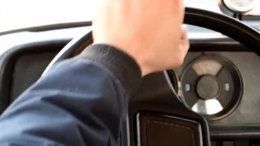 Adam eski bir araba kullanıyor. Direksiyon simidi üzerinde erkek el.