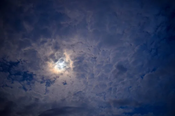 O céu noturno, a lua escondida atrás das nuvens — Fotografia de Stock