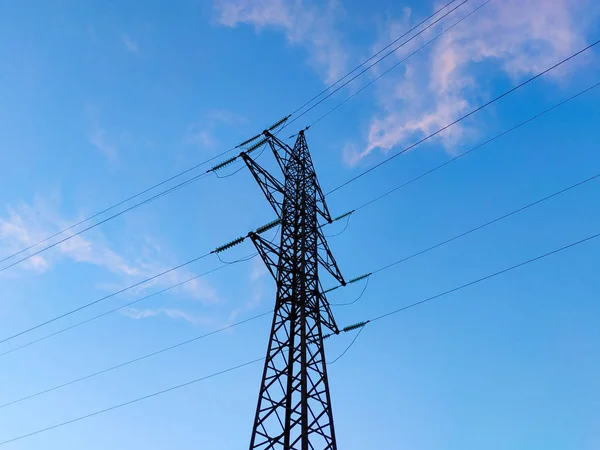 Yüksek voltajlı elektrik hatları mavi gökyüzü bulutlu destekler. Elektrik Sanayi. — Stok fotoğraf