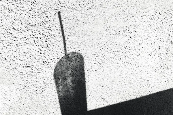 Sombra de um copo com um tubo de bebida em uma parede branca — Fotografia de Stock