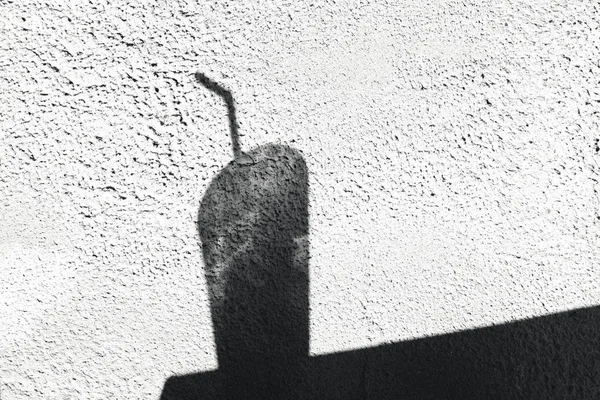 Shadow of a glass with a drinking tube on a white wall — Stock Photo, Image