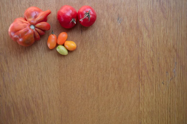 Tomaten auf einem hölzernen Hintergrund. Ansicht von oben. Freiraum für Text. — Stockfoto