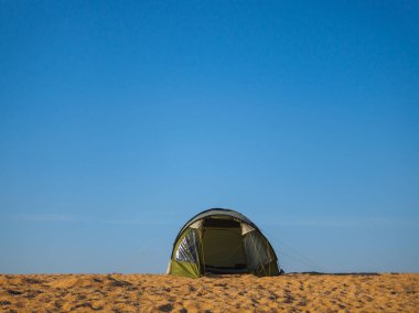 Deniz kıyısı sıcak sıcak güneşin altında beş-koltuklu çadır