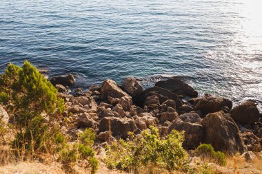 Büyük taşlar mavi deniz kıyı şeridi boyunca bir sürü