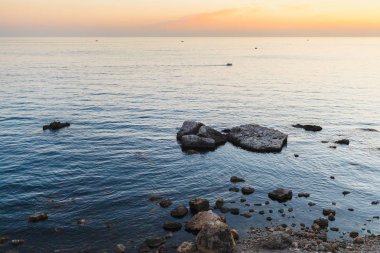 Büyük taşlar mavi deniz kıyı şeridi boyunca bir sürü