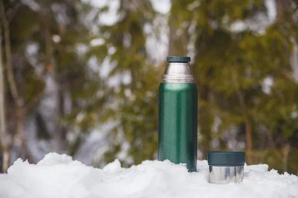 Tea from a thermos in the winter forest