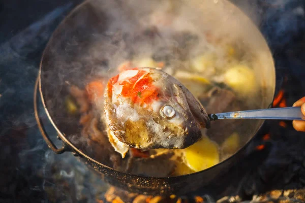 Cooking in a pot on the fire of red fish soup