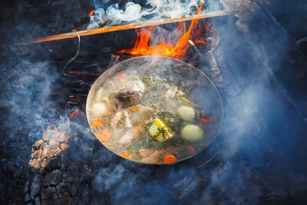Cooking in a pot on the fire of red fish soup