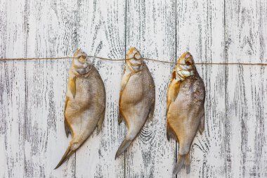 Üç kurutulmuş balık çipura üzerinde ahşap masa lambası yalan