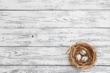 Paskalya yumurtaları hafif ahşap masa ve arka plan üzerinde bir yuva içinde yalan
