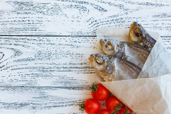 Tre orate di pesce essiccate si trovano su un tavolo di legno leggero — Foto Stock