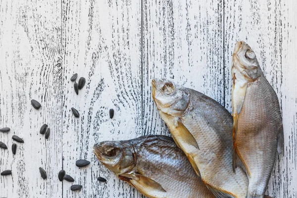Tres doradas de pescado secas yacen sobre una mesa de madera clara —  Fotos de Stock