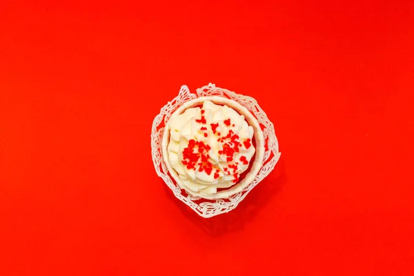 Cupcake com creme branco delicado em um fundo vermelho — Fotografia de Stock