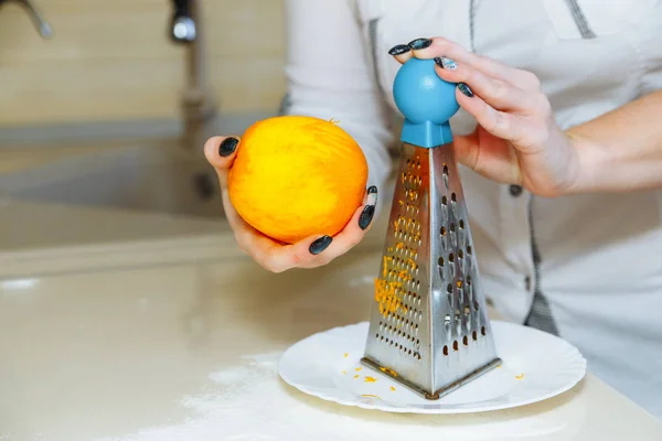 Cucinare cupcake a casa. Ragazza griglia arancione scorza — Foto Stock