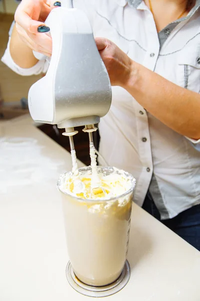 Matlagning cupcakes hemma. Flicka piskor grädde i mixer — Stockfoto