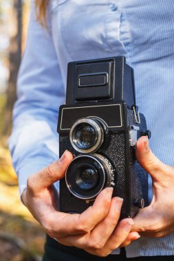 Bir kız onun elinde tutan bahar ormandaki yaşlı bir film fotoğraf makinesi