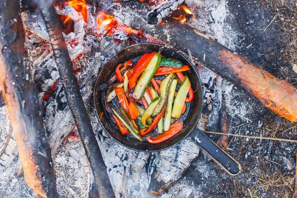 A dish of red bell peppers and cucumbers in a pan on a fire — Stock Photo, Image