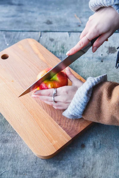 Flicka skär ett äpple i skogen — Stockfoto