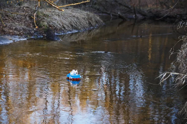 Barco de juguete navegando en el río al atardecer — Foto de Stock