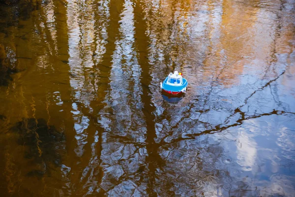 Barco de juguete navegando en el río al atardecer — Foto de Stock